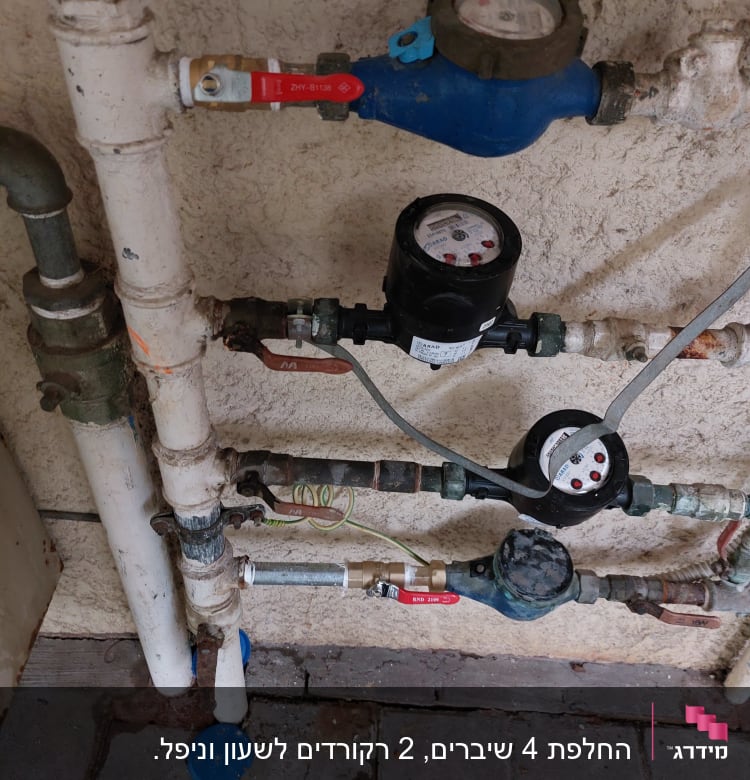 מד מים עם צינורות וברזים על קיר